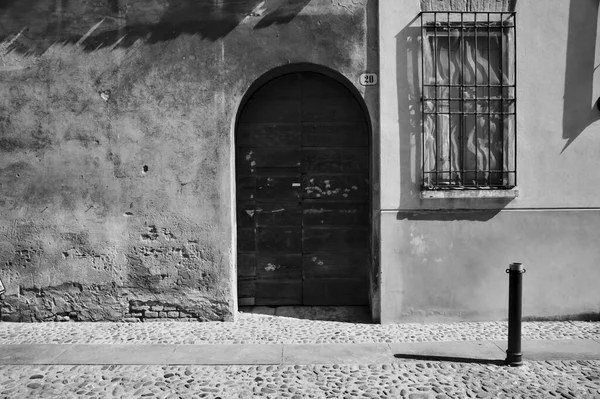 Ξύλινη Πόρτα Και Ένα Παράθυρο Πλέγμα Παράθυρο Ένα Δρόμο Μαύρο — Φωτογραφία Αρχείου