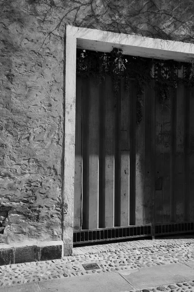 Garaj kapısı ve yol tabelası. Siyah ve beyaz bir sokakta.