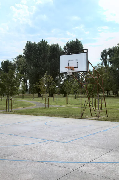 Bulutlu bir günde halka açık bir parkta basketbol sahasının basketbol potası.