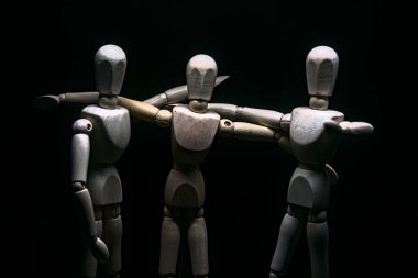 Mankenler birbirlerine sarılırken içlerinden biri kolunu kameraya doğrultuyor.