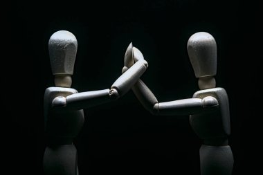 Kollarını sıkıca tutarak hareket eden iki manken.