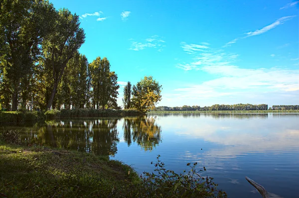 秋天落日的湖畔 树木丛生 天空洒满了水 — 图库照片