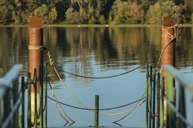 Gün batımında bir limanın kutupları ve suya yansıyan yansımaları.