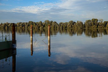 Gün batımında bir limanın kutupları ve suya yansıyan yansımaları.