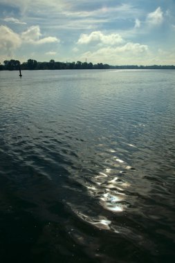 Güneşin yansıması olan bir göl açık bir günde suyun üzerinde.