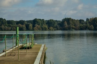 Sonbaharın başlarında, açık bir günde, bir gölün kıyısında yüzer halde.