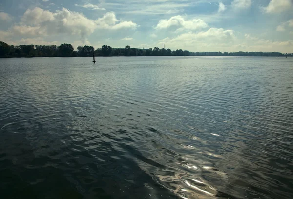 A lake with the reflection of the sun on the water on a clear day