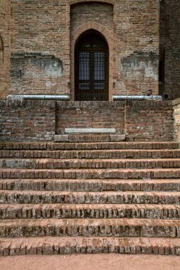 Tuğla duvardaki kapıya çıkan tuğla merdiven.
