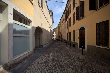 Güneşli bir günde, İtalyan kasabasının gölgesinde kaldırımlı bir cadde.
