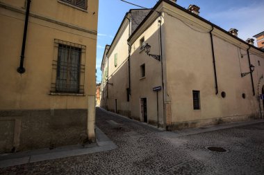 Crossroads between two cobbled street and the corner of a building seen from the opposite side of the street