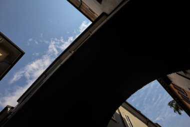 Arka planda gökyüzü olan bir caddenin üzerindeki binanın kemeri.