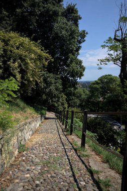 Güneşli bir günde, bir uçurumun kenarında çakıllı bir patika.