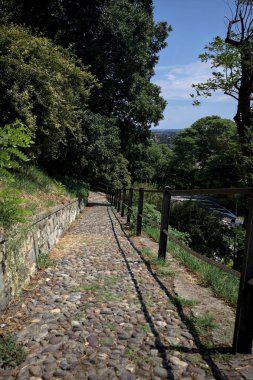 Güneşli bir günde, bir uçurumun kenarında çakıllı bir patika.