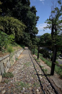 Güneşli bir günde, bir uçurumun kenarında çakıllı bir patika.