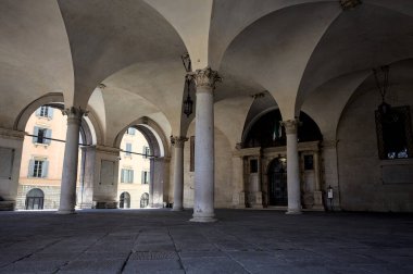 Colonnade with arches in the shade at the entrance of a palace