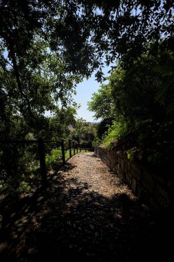 Güneşli bir günde, bir uçurumun kenarında çakıllı bir patika.