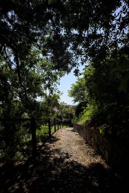 Güneşli bir günde, bir uçurumun kenarında çakıllı bir patika.