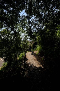 Güneşli bir günde, bir uçurumun kenarında çakıllı bir patika.