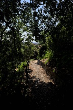 Güneşli bir günde, bir uçurumun kenarında çakıllı bir patika.