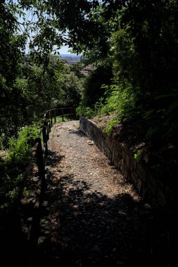 Güneşli bir günde, bir uçurumun kenarında çakıllı bir patika.