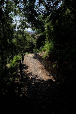 Güneşli bir günde, bir uçurumun kenarında çakıllı bir patika.