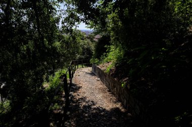 Güneşli bir günde, bir uçurumun kenarında çakıllı bir patika.