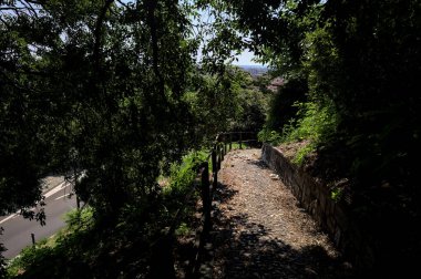 Güneşli bir günde, bir uçurumun kenarında çakıllı bir patika.