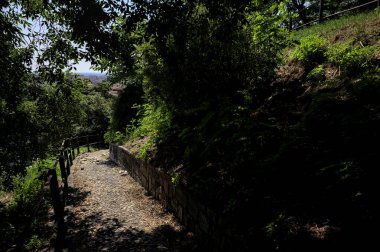 Güneşli bir günde, bir uçurumun kenarında çakıllı bir patika.