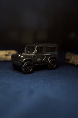 Mantova, Italy - 10TH AUGUST 2025 - Hot Wheels replica of a Land Rover Defender 90 pretending to cross a creek with trunks in it