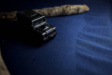 Mantova, Italy - 10TH AUGUST 2025 - Hot Wheels replica of a Land Rover Defender 90 pretending to cross a creek with trunks in it