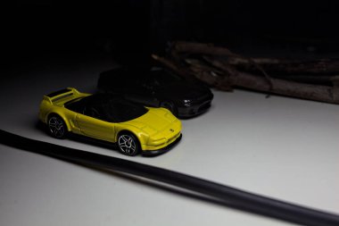 Mantova, Italy - 10TH AUGUST 2025 - Hot Wheels replicas of a black Nissan Skyline GT-R R32 and a yellow 1990 Acura NSX pretending to drift during a race on a mountain pass