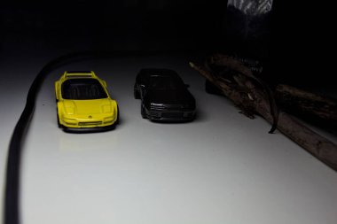 Mantova, Italy - 10TH AUGUST 2025 - Hot Wheels replicas of a black Nissan Skyline GT-R R32 and a yellow 1990 Acura NSX pretending to drift during a race on a mountain pass