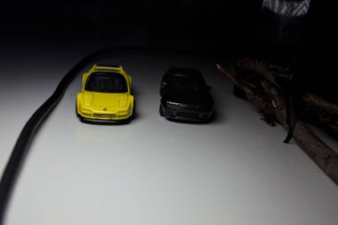 Mantova, Italy - 10TH AUGUST 2025 - Hot Wheels replicas of a black Nissan Skyline GT-R R32 and a yellow 1990 Acura NSX pretending to drift during a race on a mountain pass