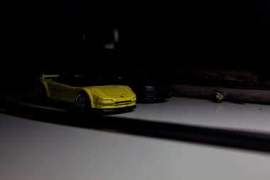 Mantova, Italy - 10TH AUGUST 2025 - Hot Wheels replicas of a black Nissan Skyline GT-R R32 and a yellow 1990 Acura NSX pretending to drift during a race on a mountain pass