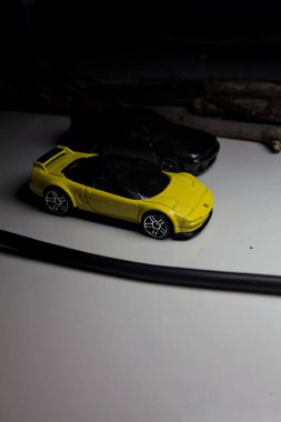 Mantova, Italy - 10TH AUGUST 2025 - Hot Wheels replicas of a black Nissan Skyline GT-R R32 and a yellow 1990 Acura NSX pretending to drift during a race on a mountain pass