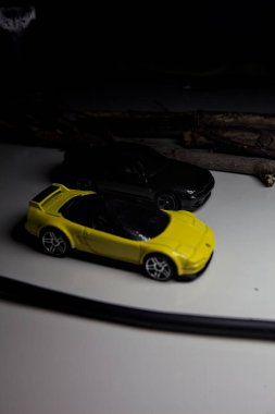 Mantova, Italy - 10TH AUGUST 2025 - Hot Wheels replicas of a black Nissan Skyline GT-R R32 and a yellow 1990 Acura NSX pretending to drift during a race on a mountain pass