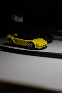 Mantova, Italy - 10TH AUGUST 2025 - Hot Wheels replicas of a black Nissan Skyline GT-R R32 and a yellow 1990 Acura NSX pretending to drift during a race on a mountain pass