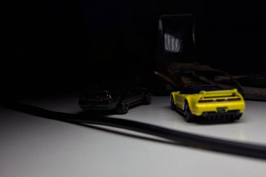 Mantova, Italy - 10TH AUGUST 2025 - Hot Wheels replicas of a black Nissan Skyline GT-R R32 and a yellow 1990 Acura NSX pretending to drift during a race on a mountain pass