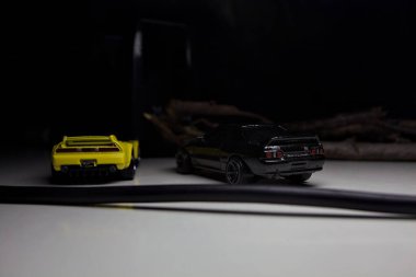 Mantova, Italy - 10TH AUGUST 2025 - Hot Wheels replicas of a black Nissan Skyline GT-R R32 and a yellow 1990 Acura NSX pretending to drift during a race on a mountain pass