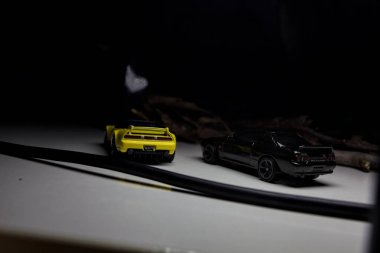 Mantova, Italy - 10TH AUGUST 2025 - Hot Wheels replicas of a black Nissan Skyline GT-R R32 and a yellow 1990 Acura NSX pretending to drift during a race on a mountain pass