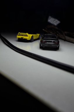 Mantova, Italy - 10TH AUGUST 2025 - Hot Wheels replicas of a black Nissan Skyline GT-R R32 and a yellow 1990 Acura NSX pretending to drift during a race on a mountain pass