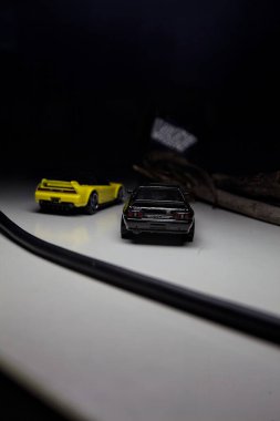Mantova, Italy - 10TH AUGUST 2025 - Hot Wheels replicas of a black Nissan Skyline GT-R R32 and a yellow 1990 Acura NSX pretending to drift during a race on a mountain pass