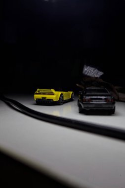 Mantova, Italy - 10TH AUGUST 2025 - Hot Wheels replicas of a black Nissan Skyline GT-R R32 and a yellow 1990 Acura NSX pretending to drift during a race on a mountain pass