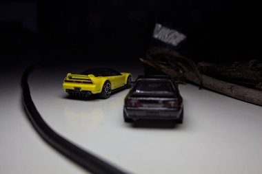 Mantova, Italy - 10TH AUGUST 2025 - Hot Wheels replicas of a black Nissan Skyline GT-R R32 and a yellow 1990 Acura NSX pretending to drift during a race on a mountain pass