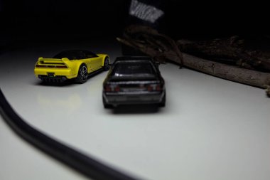 Mantova, Italy - 10TH AUGUST 2025 - Hot Wheels replicas of a black Nissan Skyline GT-R R32 and a yellow 1990 Acura NSX pretending to drift during a race on a mountain pass