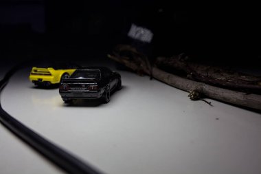 Mantova, Italy - 10TH AUGUST 2025 - Hot Wheels replicas of a black Nissan Skyline GT-R R32 and a yellow 1990 Acura NSX pretending to drift during a race on a mountain pass