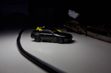 Mantova, Italy - 10TH AUGUST 2025 - Hot Wheels replicas of a black Nissan Skyline GT-R R32 and a yellow 1990 Acura NSX pretending to drift during a race on a mountain pass