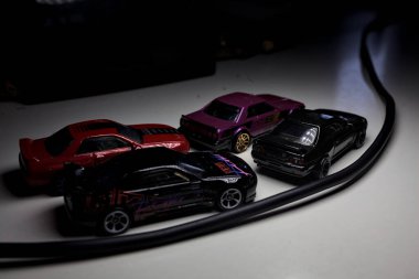 Mantova, Italy - 10TH AUGUST 2025 - Hot Wheels replicas of various Nissan Skyline models from 80s and 90s parked on a passing place of a mountain pass at night