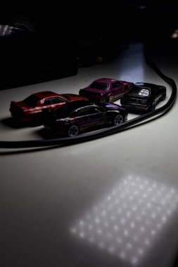 Mantova, Italy - 10TH AUGUST 2025 - Hot Wheels replicas of various Nissan Skyline models from 80s and 90s parked on a passing place of a mountain pass at night