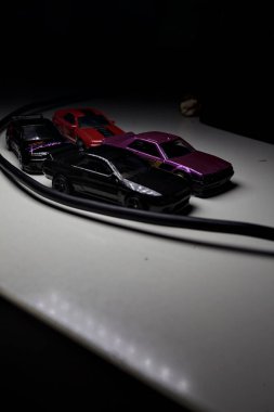 Mantova, Italy - 10TH AUGUST 2025 - Hot Wheels replicas of various Nissan Skyline models from 80s and 90s parked on a passing place of a mountain pass at night